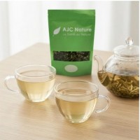 Moment de dégustation convivial et serein avec une théière en verre et le sachet de thé blanc bio AJC Nature.
